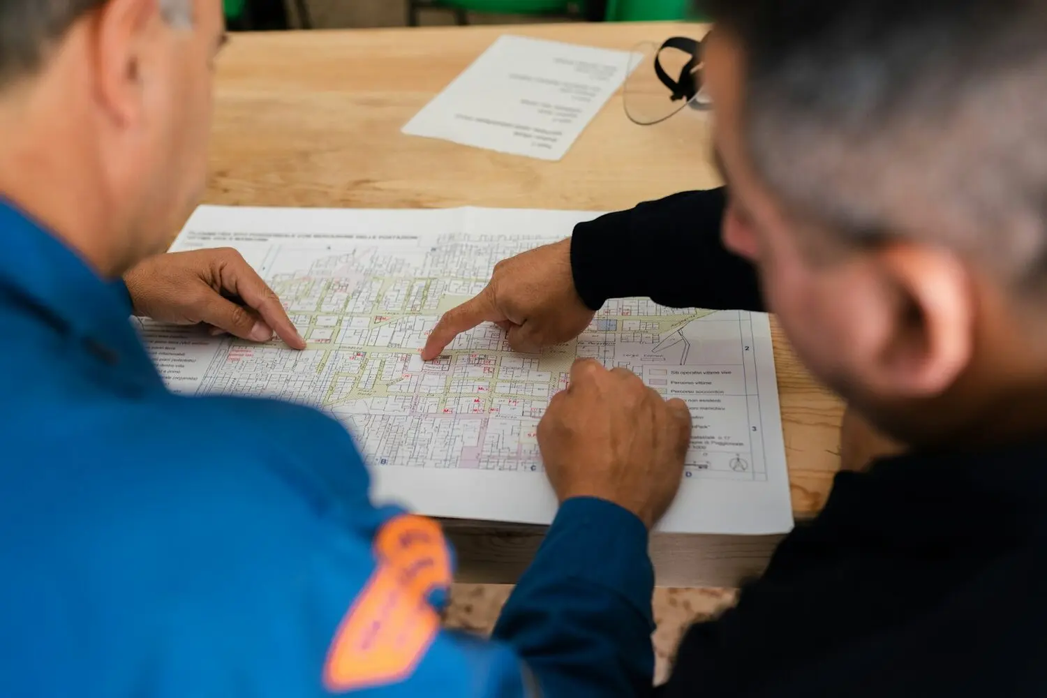 Dos técnicos revisando sobre la mesa los planos y la documentación de una instalación